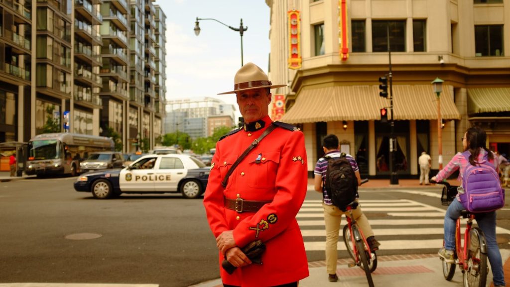 Royal Canadian Mounted Police officer in uniform standing in a busy Washington DC intersection.