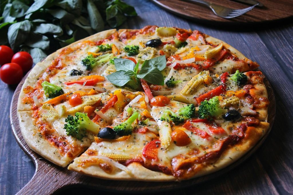 Delicious homemade vegetable pizza with fresh toppings including broccoli, olives, and tomatoes.