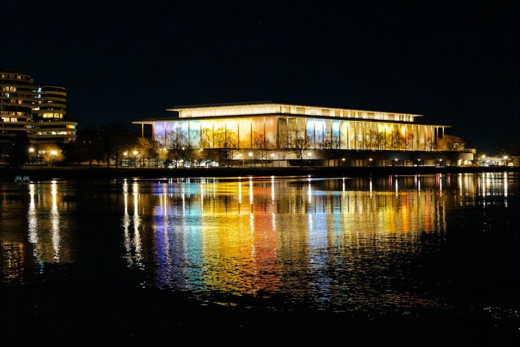 a building is lit up at night by the water
