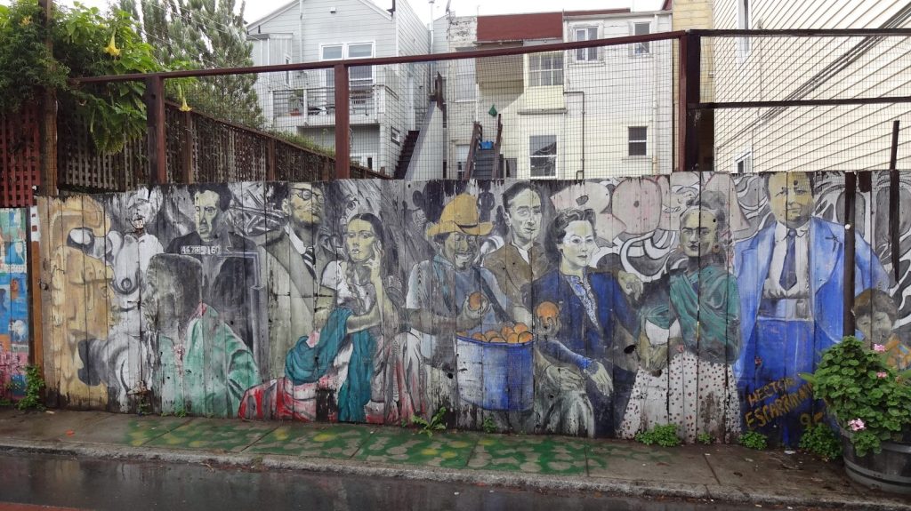 Mural of diverse people painted on a wooden fence