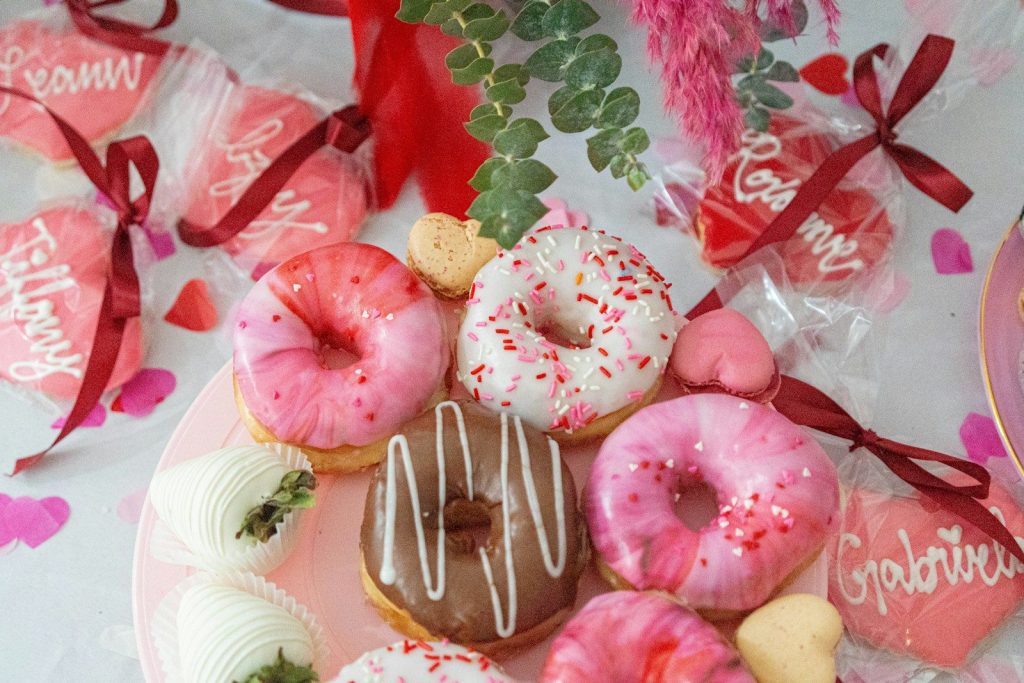 A pink plate topped with donuts covered in frosting