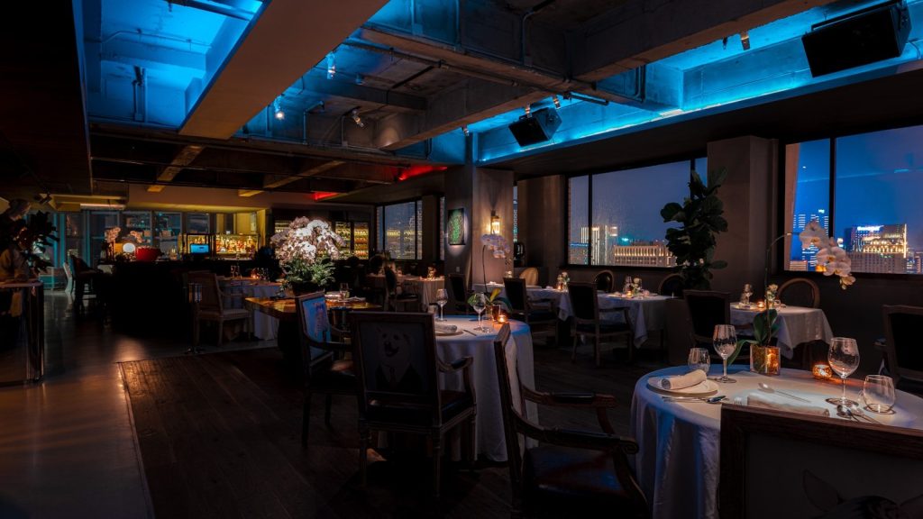 a dimly lit restaurant with a view of the city