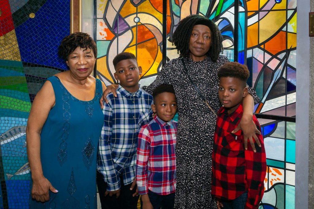a group of people standing in front of a stained glass window