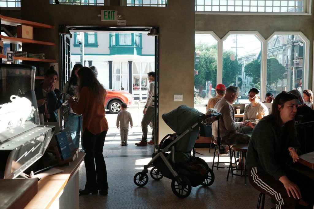 People in a busy coffee shop with a stroller