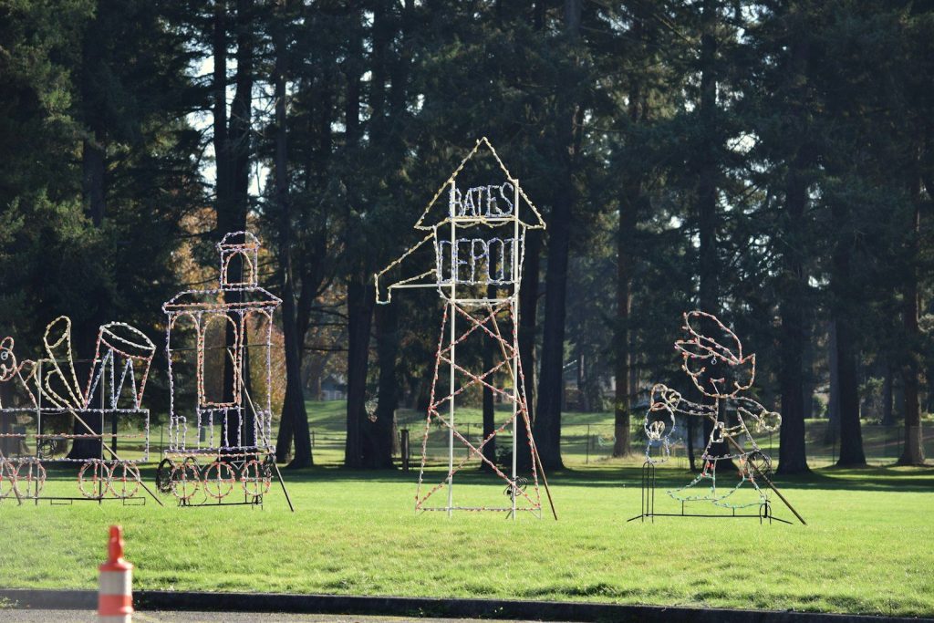 a group of sculptures in a park with trees in the background