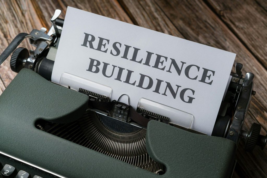 a close up of a typewriter with a paper that reads resilince building