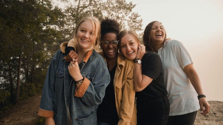 Four women laughing together outdoors