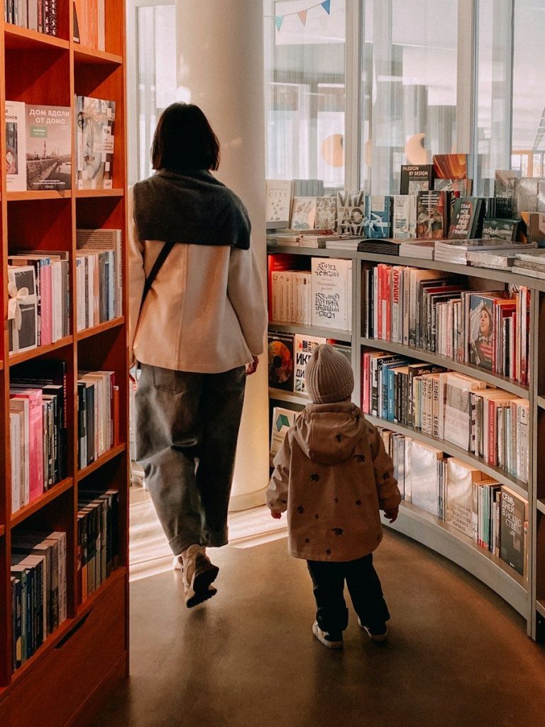 Woman and child walk through a library