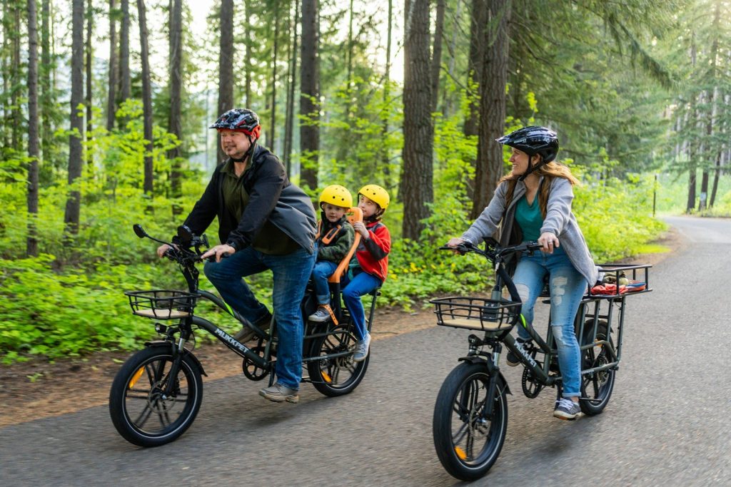 a family of three riding bikes down a road