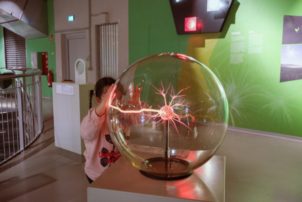 Child touching a plasma ball in a science exhibit