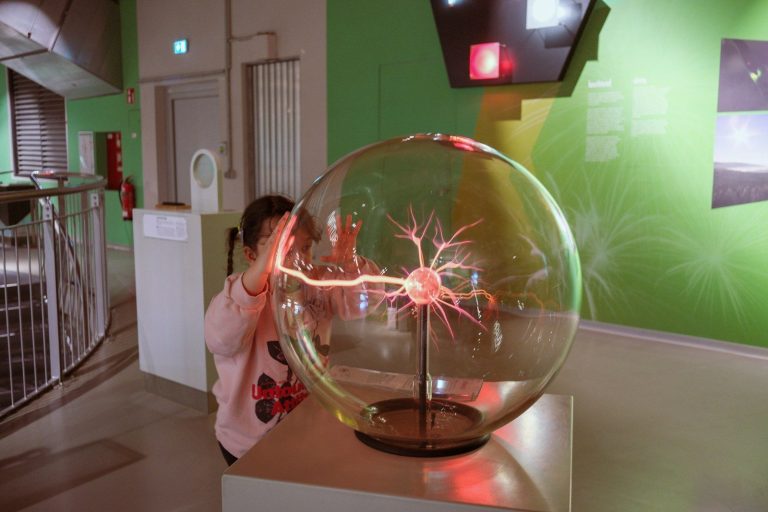 Child touching a plasma ball in a science exhibit
